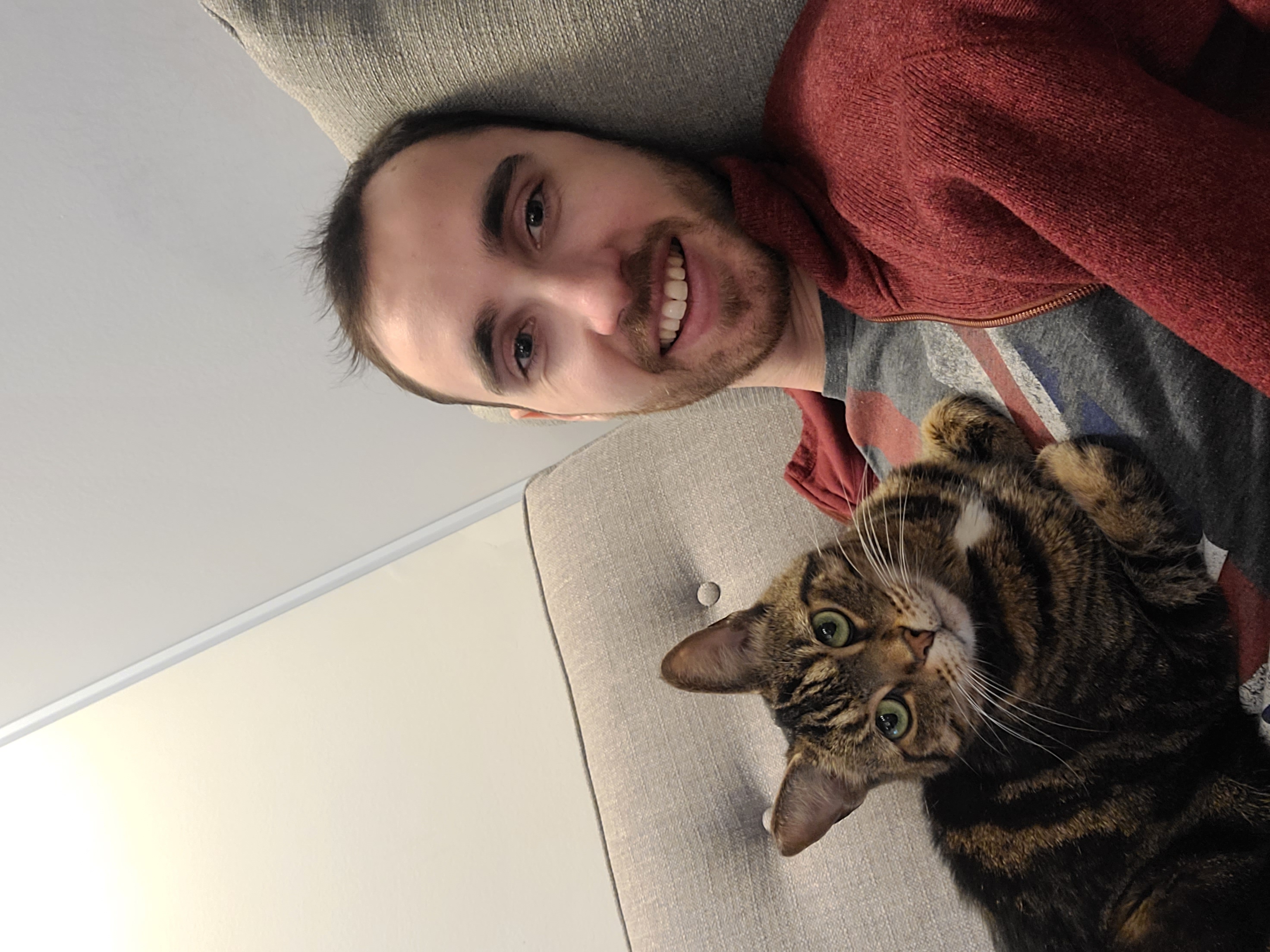 Connor relaxing on the couch with his cat Zoey