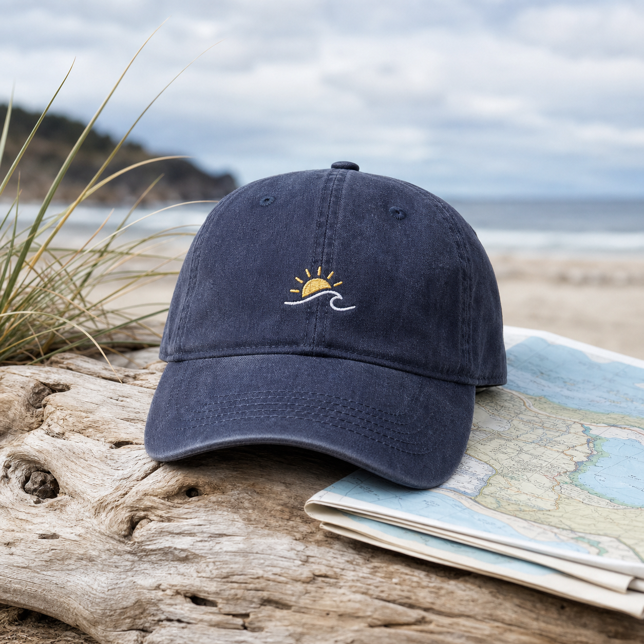 A navy cap with a small wave and sun emblem on a beach map